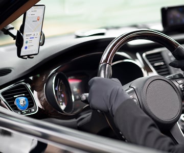 Driver using a navigation app on a smartphone mounted in a car